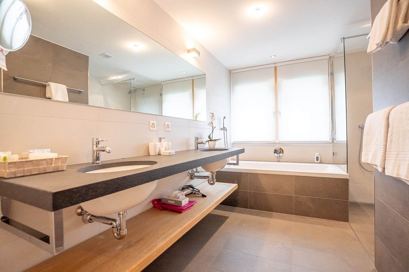 Helles Badezimmer mit Doppellavabo und Badewanne